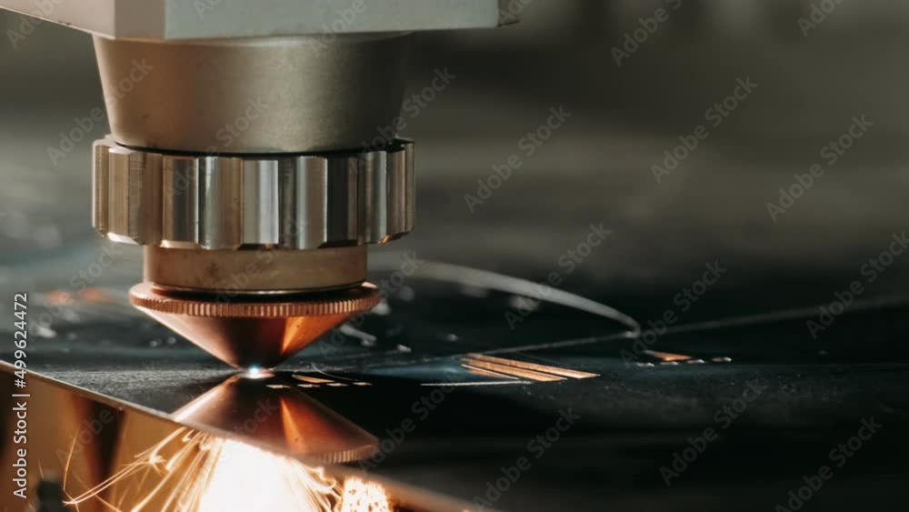The industrial laser cutting torch cuts preparations from metal. Clip. Laser cutter in the production. Industrial cnc plasma cutting of metal plate. Closeup. lot of bright sparks.