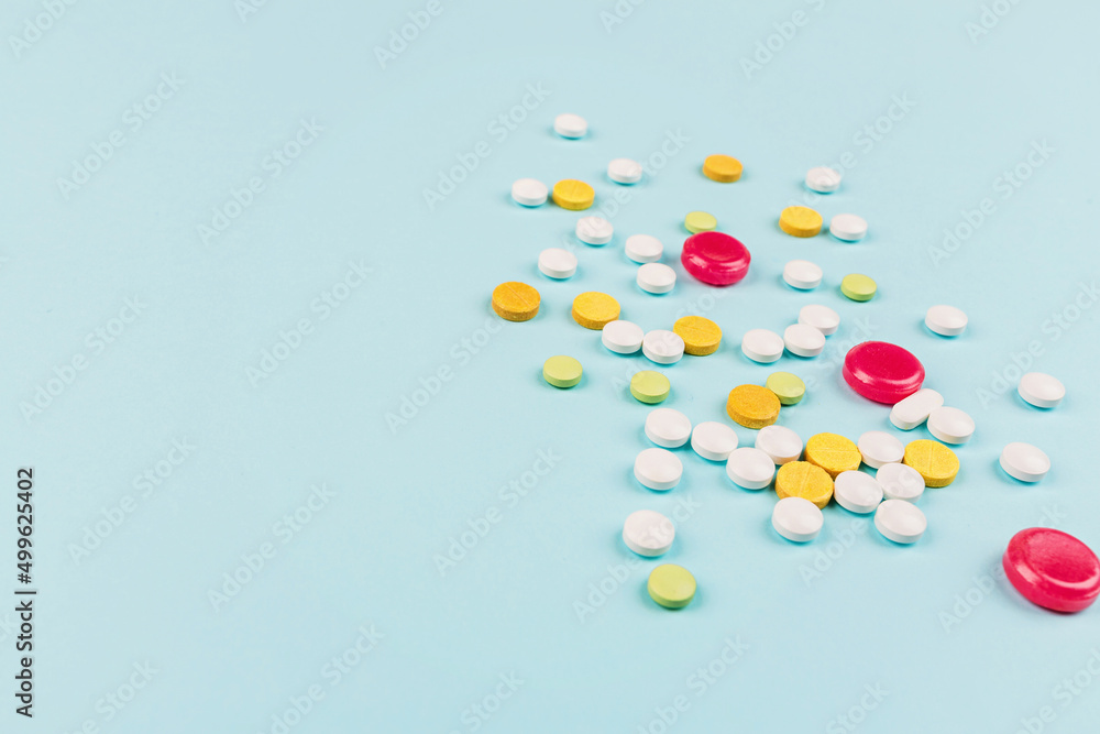 Colorful pills on a pastel blue background. Flat lay, top view, overhead, mockup, template. Pharmacy and medical concept