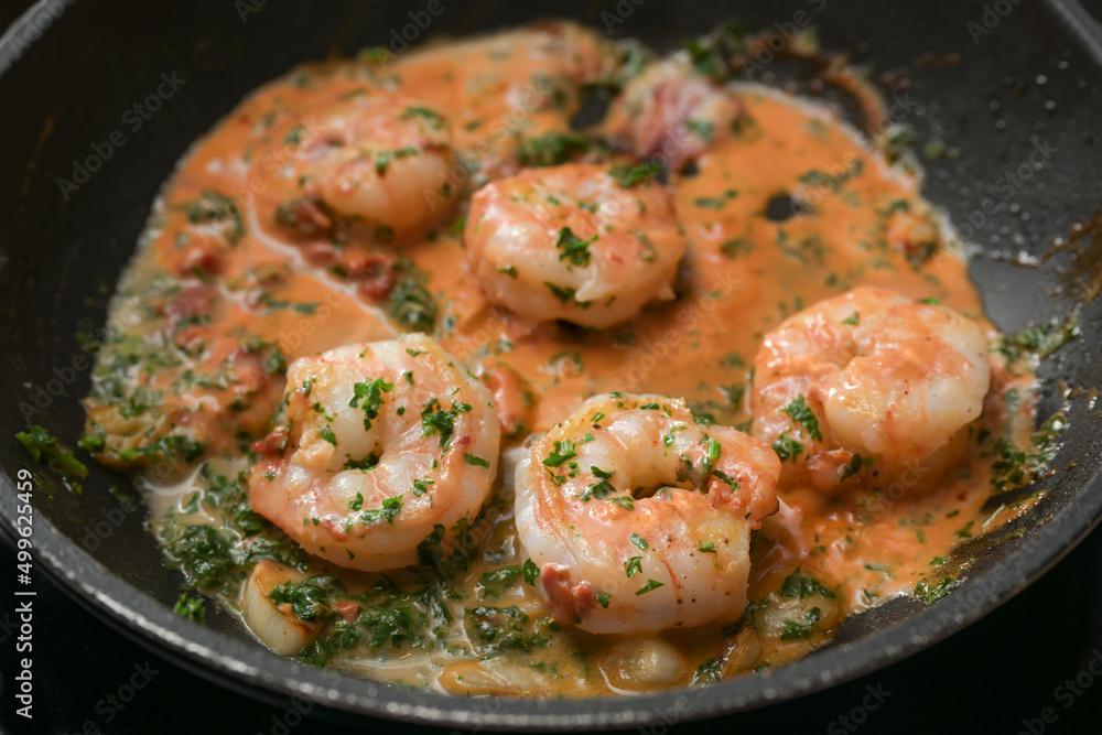 Shrimps with garlic and parsley in tomato sauce in a pan, cooking a delicious appetizer, selected focus Shrimps with garlic and parsley in tomato sauce in a pan, cooking a delicious appetizer, selected focus