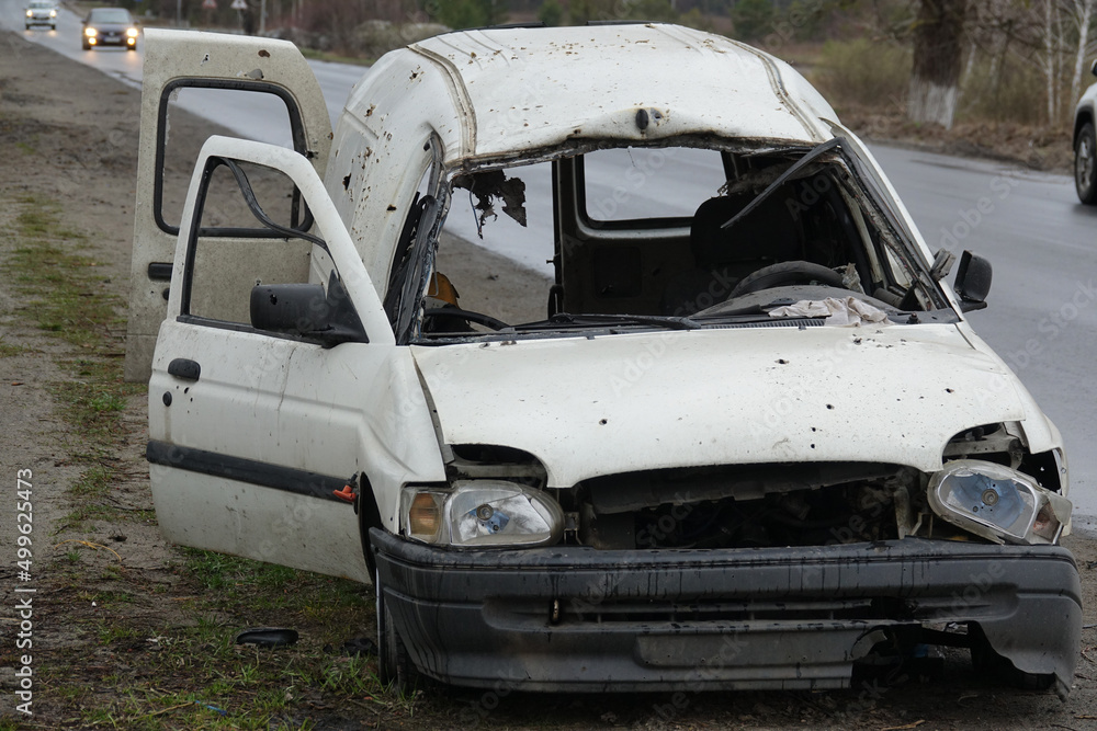 Damaged civilian car in the war in Ukraine. Shot car. Damaged civilian car in the war in Ukraine. Shot car.