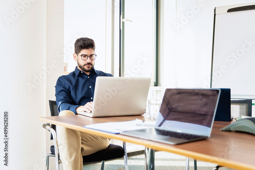 Businessman working on laptop while sitting in a modern office