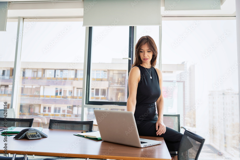 Thinking businesswoman working on laptop in a modern office Thinking businesswoman working on laptop in a modern office