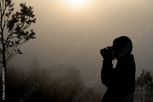 silhouette of photographer taking picture of landscape
