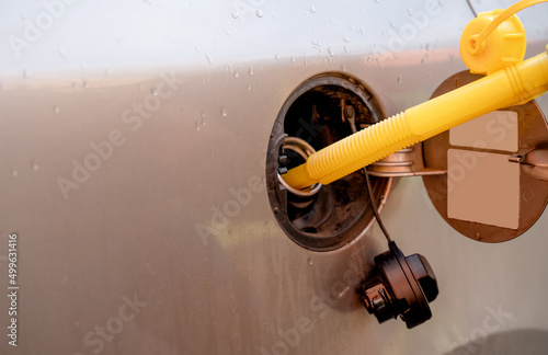 A man filling the fuel tank of his car with diesel fuel from the jerry can as there is no fuel at the petrol station, close up. The fuel crisis is continue