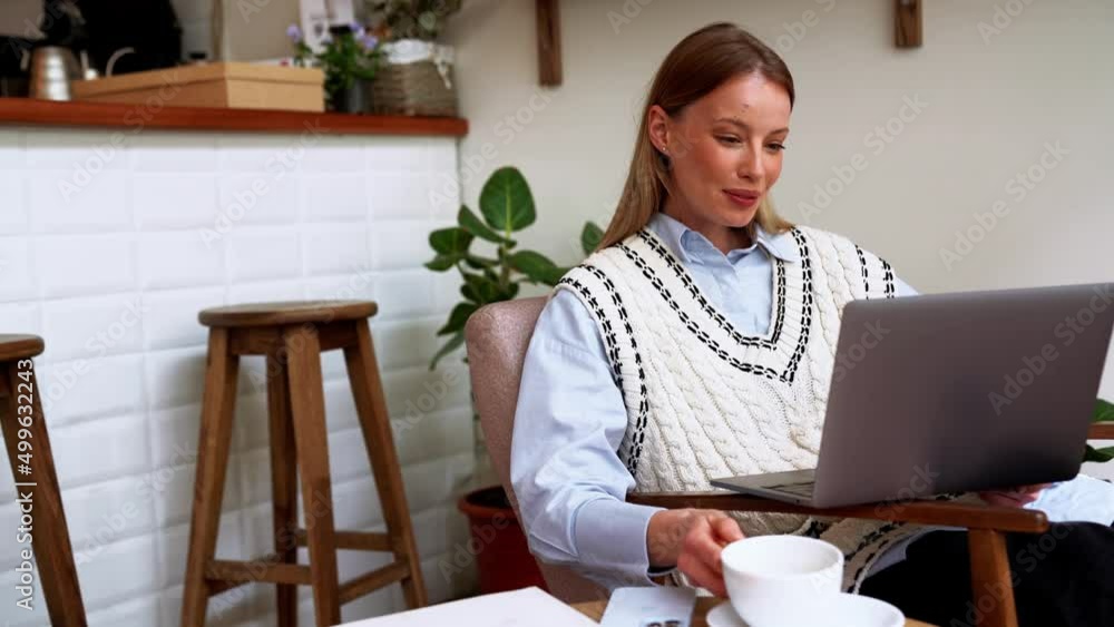 Laughing blonde woman drinking coffee and looking at laptop in the cafe Laughing blonde woman drinking coffee and looking at laptop in the cafe