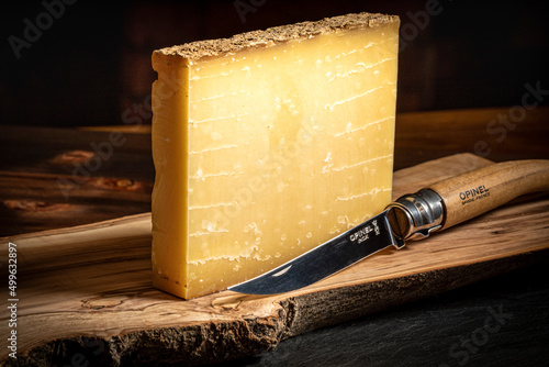 Close Up of Comte Cheddar Cheese on a Wood Cutting Board