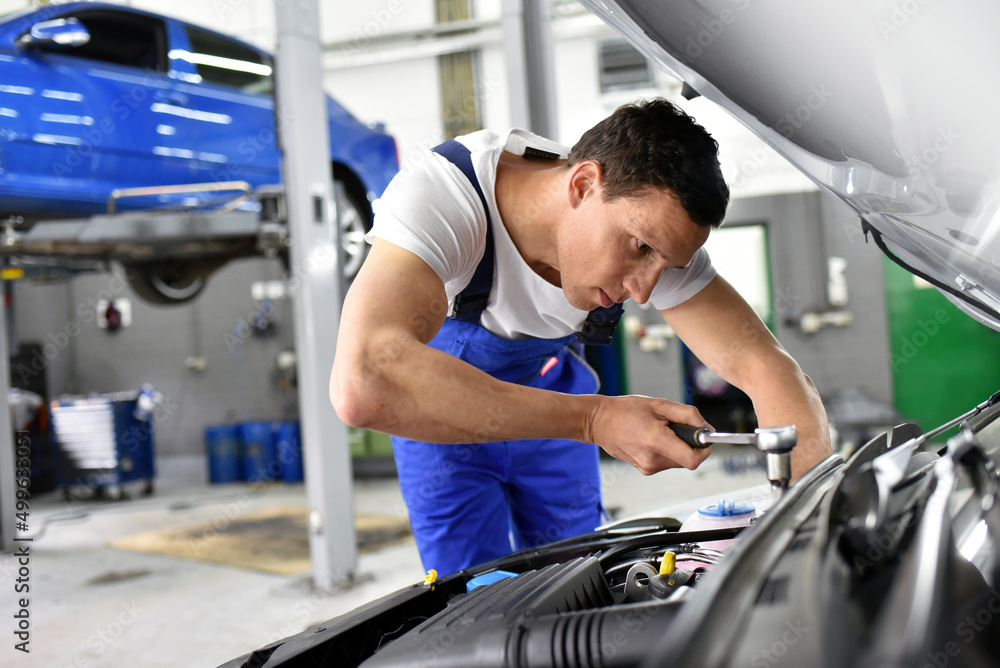 car mechanic in a workshop repairing a vehicle car mechanic in a workshop repairing a vehicle