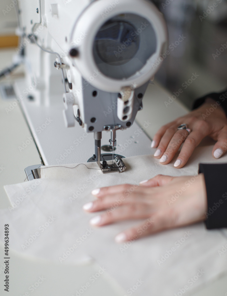 female hands at work with sewing machine