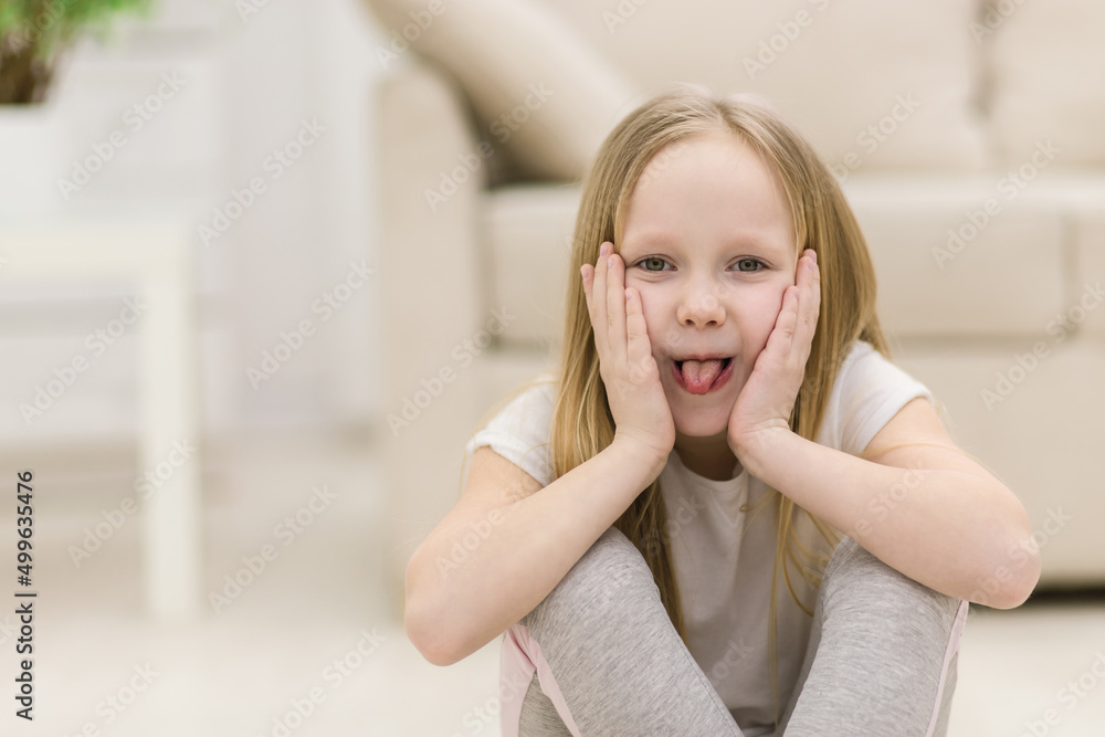 Photo of small blonde girl showing tongue. Photo of small blonde girl showing tongue.
