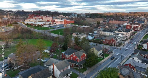 Evening light in spring scene. Homes and manufacturing factory plant in distance. Aerial view.