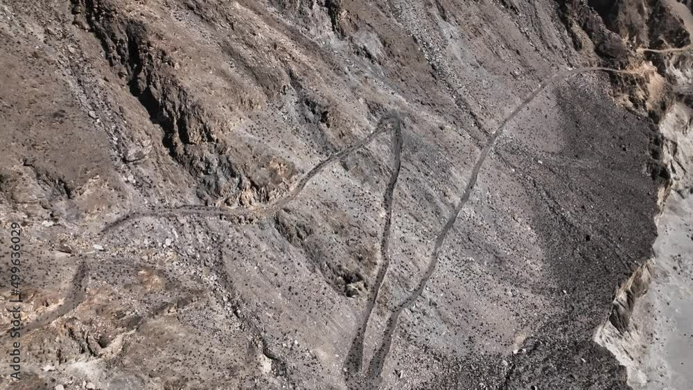 Aerial View Of Winding Old Silk Road Through Rugged Arid Mountains In Pakistan. Dolly Back Rising Aerial View Of Winding Old Silk Road Through Rugged Arid Mountains In Pakistan. Dolly Back Rising