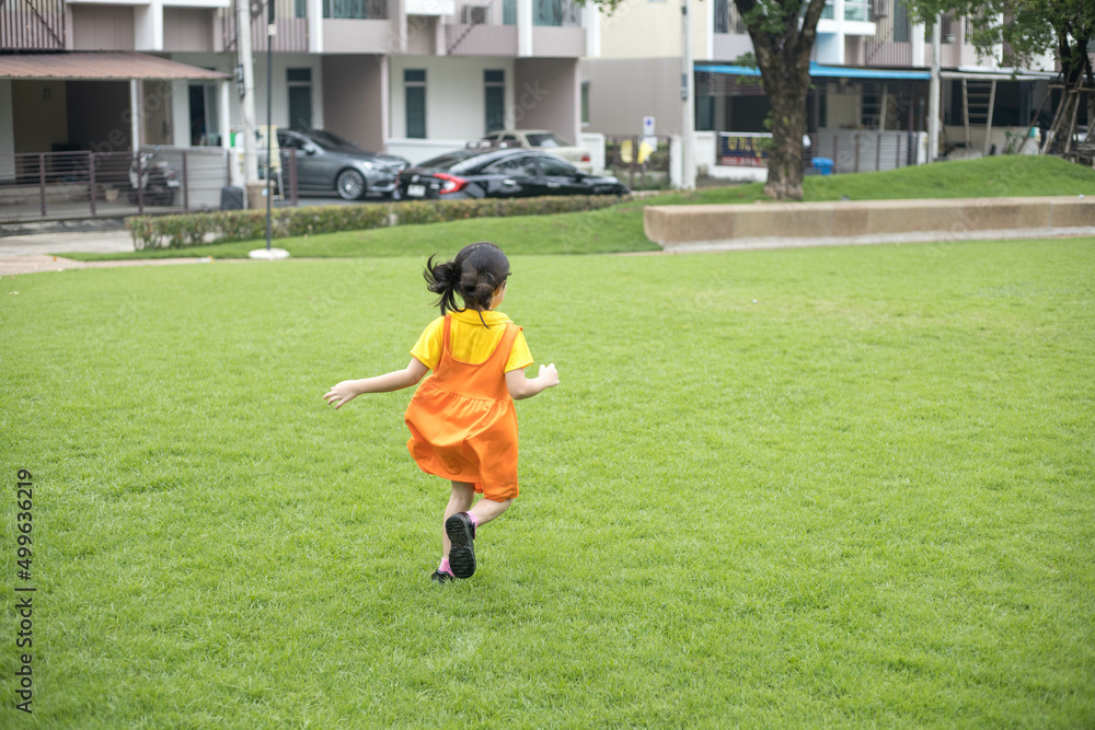Asian happy girl with orange dress is playing in the playground. Asian happy girl with orange dress is playing in the playground.