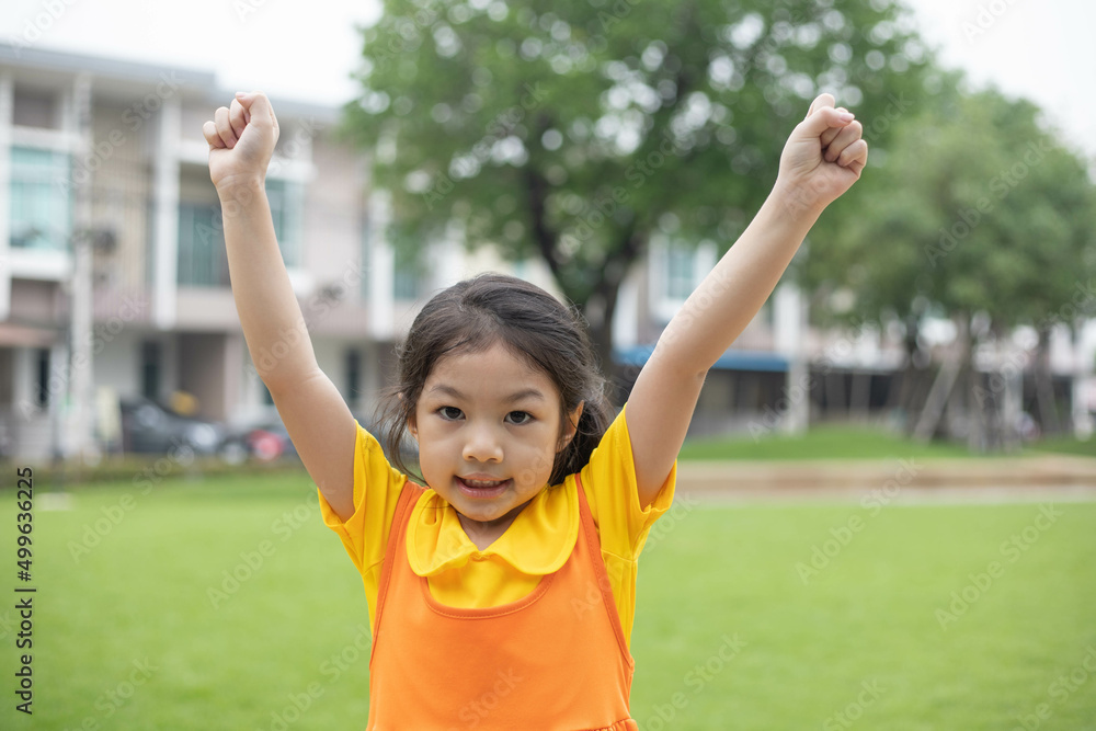 Asian happy girl with orange dress is playing in the playground. Asian happy girl with orange dress is playing in the playground.