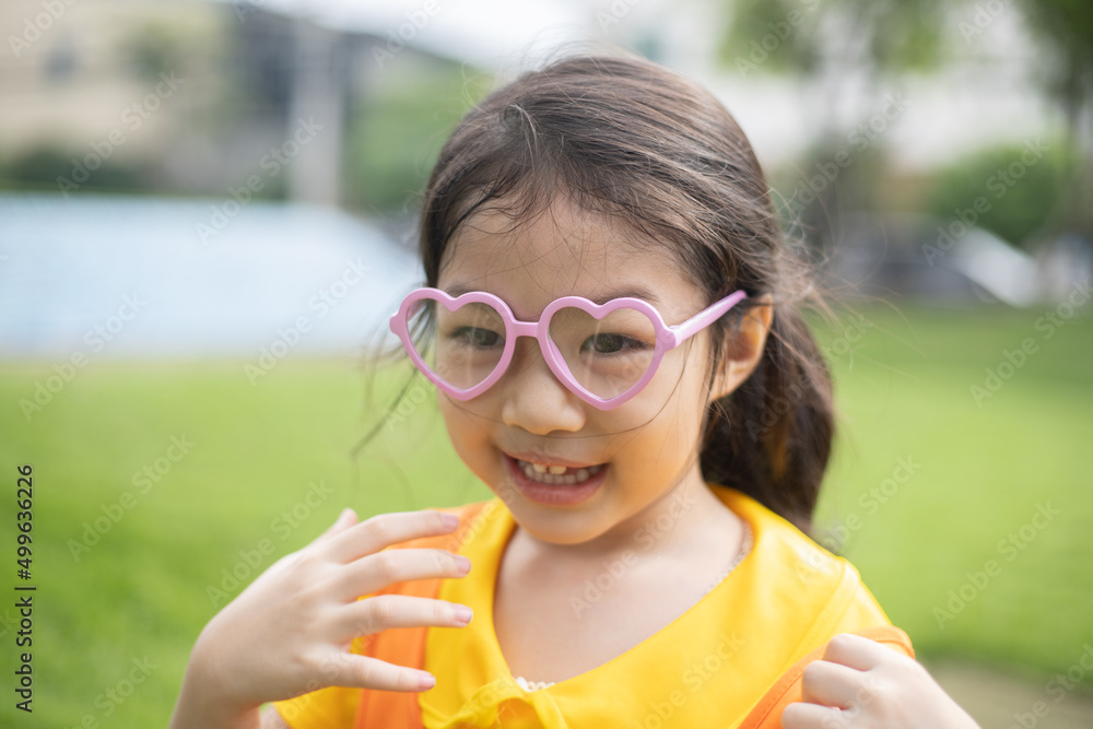 Cute Asian girl wearing glasses playing outdoor. Cute Asian girl wearing glasses playing outdoor.