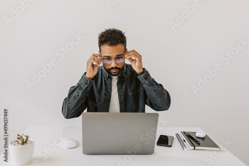 Photography Cheerful handsome black skinned guy wearing eyeglasses before starting type blog