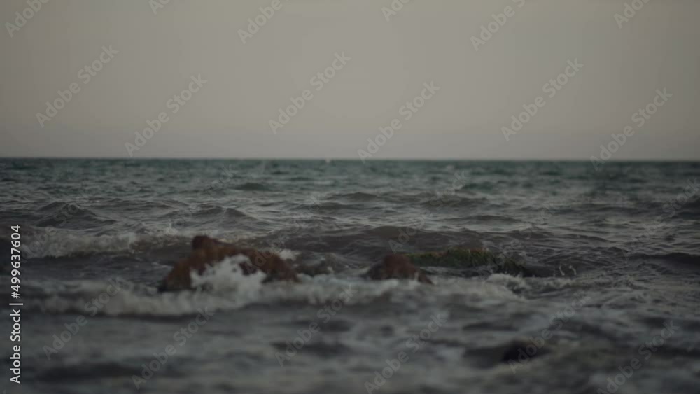 Seawave splashes at sunset on the summer beach. Slow motion. Seawave splashes at sunset on the summer beach. Slow motion.