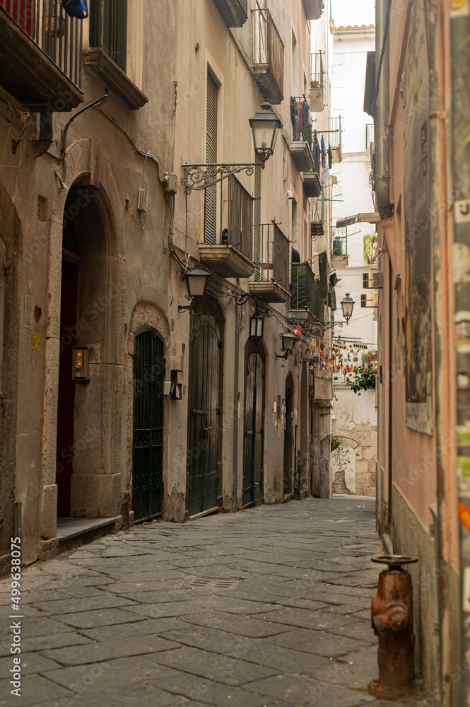 Ancient streets of the southern sea city. Lovely houses with shutters. Tourism in old Europe - Salerno, Southern Italy.