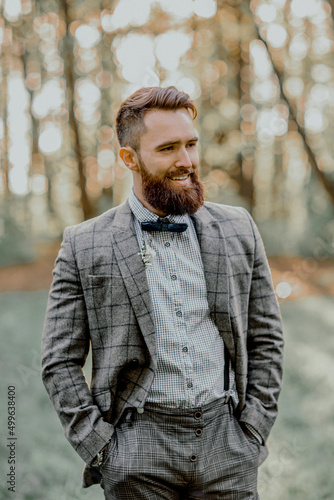 Handsome bearded groom smiling. Outdoors wedding.