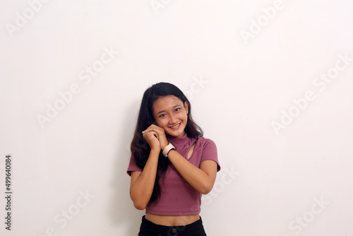 asian girl holds chin with both hands looking at camera isolated on white background
