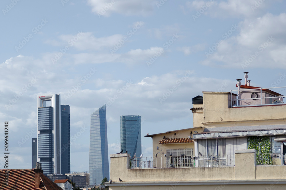 Urban scene with old buildings in city and skyscrapers in Madrid