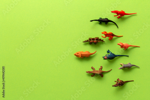Top view toy dinosaurs on green background