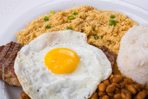 Steak with egg on top, rice, farofa and beans. Brazilian food. (ID: 499644467)