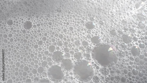 Soft liquid soapy foam on water surface as texture or background, video 4k resolution