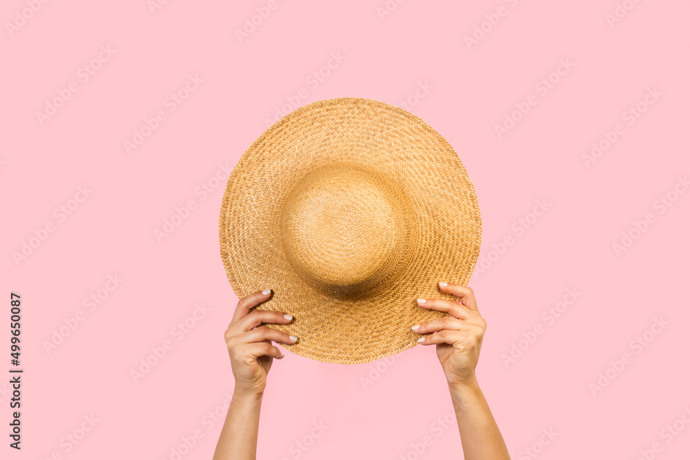 Mujer con las brazos para arriba sosteniendo un sombrero de paja sobre un  fondo rosa pastel liso y aislado. Vista de frente y de cerca. Copy space  Stock 写真 | Adobe Stock