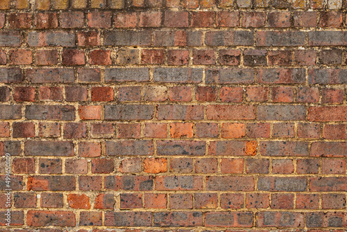 Old weathered red brick wall closeup as background