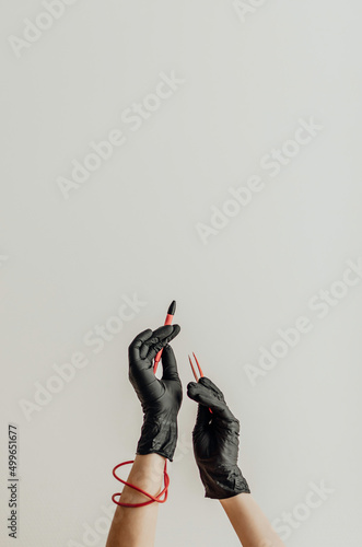 Female hands in black medical gloves hold tools for electrolysis. photo