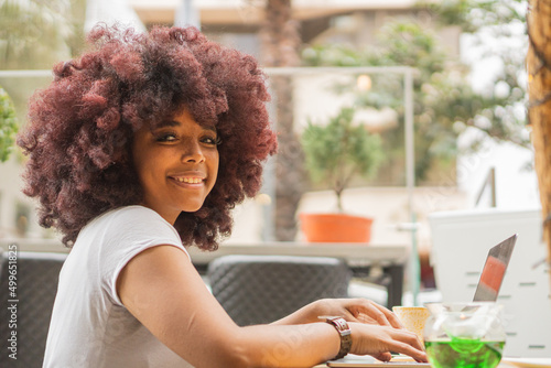 Young Afro woman in a coffee shop working online