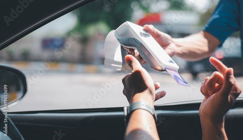 Obraz na plátně Gas station worker swipe mockup credit card via payment terminal after giving a price quote to the customer sitting in the car