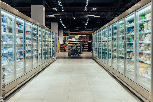 Foto Empty supermarket aisle with refrigerators