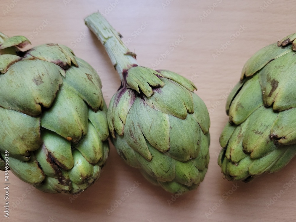 Fototapeta premium Artichokes on a wooden background. Fresh vegetables