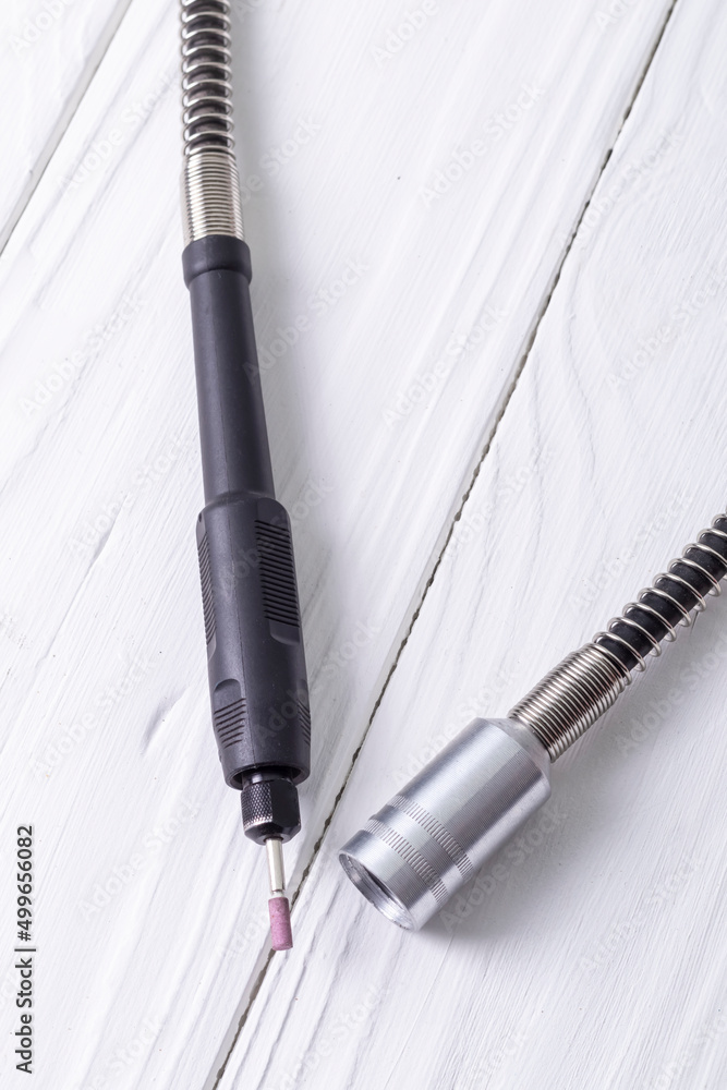 Naklejka premium dremel. precise and accurate processing of the product. on a wooden background in retro style. white color