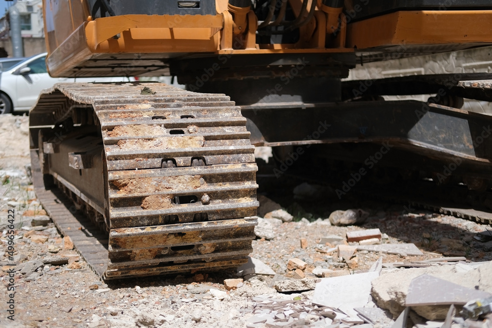 Fototapeta premium Excavator caterpillars at construction site close-up