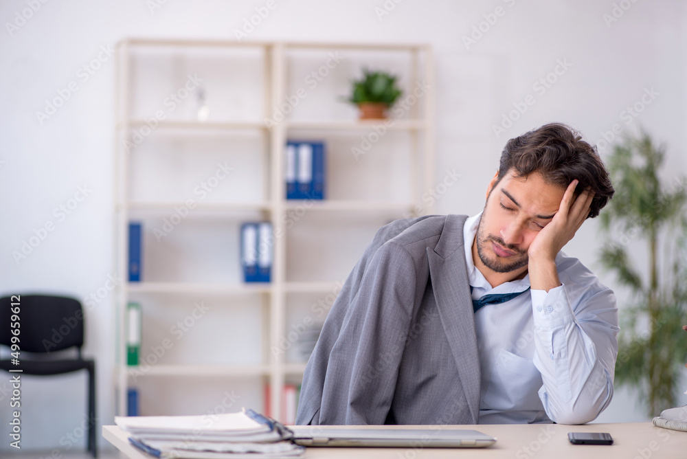 Young male employee in oversleeping concept Young male employee in oversleeping concept