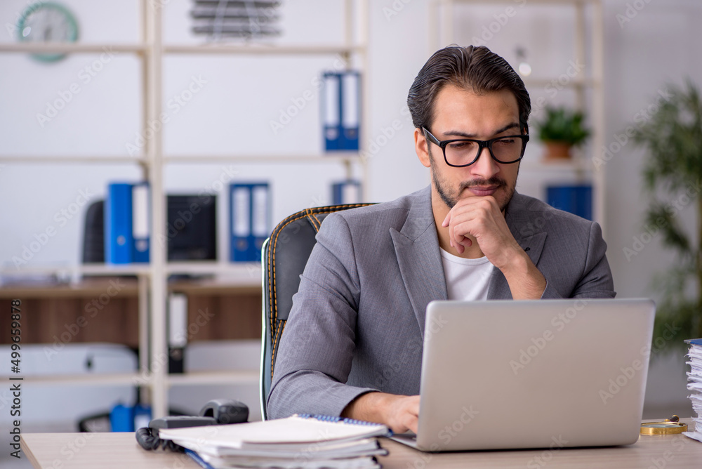 Young male employee working in the office Young male employee working in the office