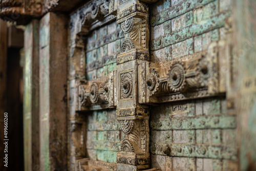 Close up Indian wooden old door vintage texture background. Ancient Mughal Art Door doors made of authentic material in an old building entrance. Weathered wood carved door in India. Selective focus