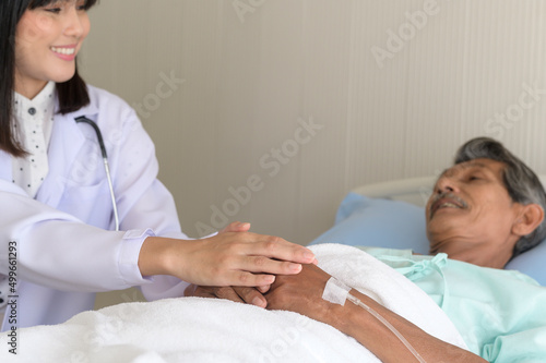 Doctor holding senior patient s hand in hospital  health care and medical concept..