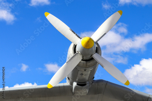 Close up of airplane turboprop engine with propeller on a cloudy blue sky background