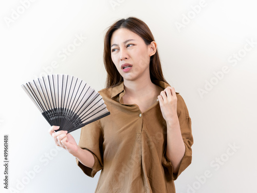 heatstroke from hot weather. Woman using paper fan to cooling herself in summer day.