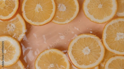 Falling of orange slice into water, top view