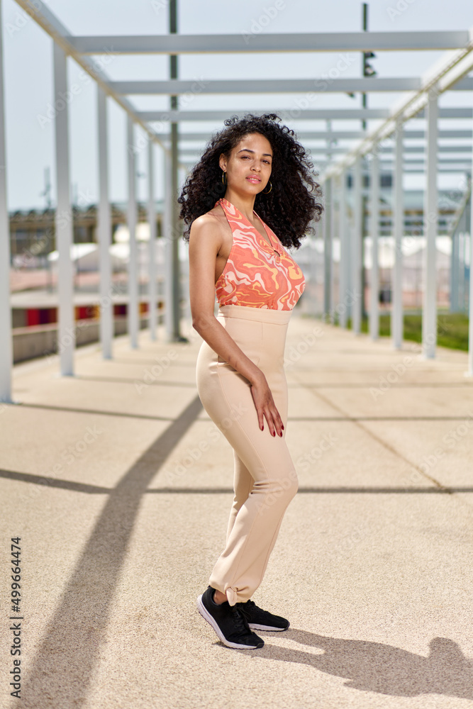 Enjoyment - free happy american african woman with afro enjoying sunset. Beautiful woman in white dress in the city Enjoyment - free happy american african woman with afro enjoying sunset. Beautiful woman in white dress in the city