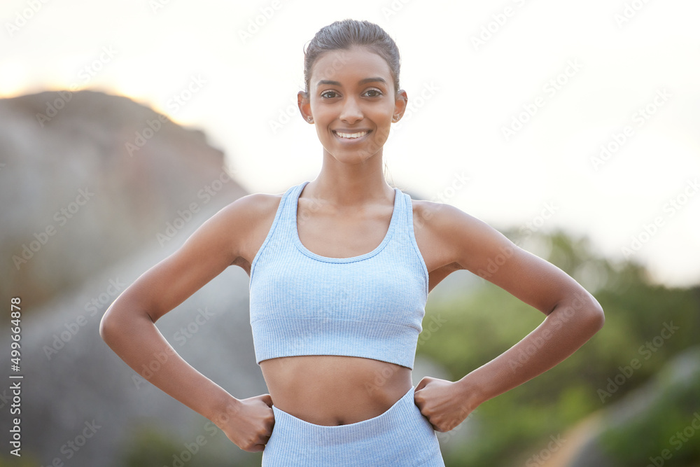 Fototapeta premium Feeling stronger than ever. Shot of a young woman getting ready for a jog outdoors.