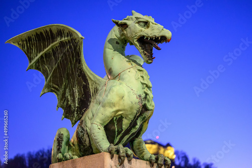 Dragon bridge and the Dragon statue with the Ljubljana castle at night