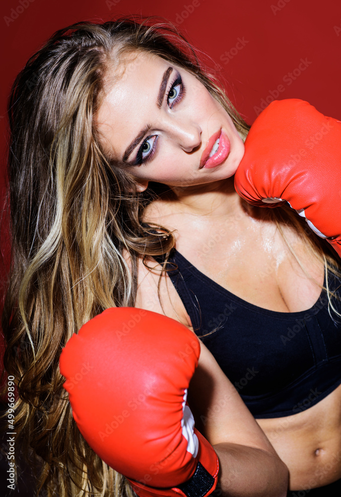 Beautiful boxer girl in boxing gloves and in sportswear. Sporty Fitness woman make boxing exercises.