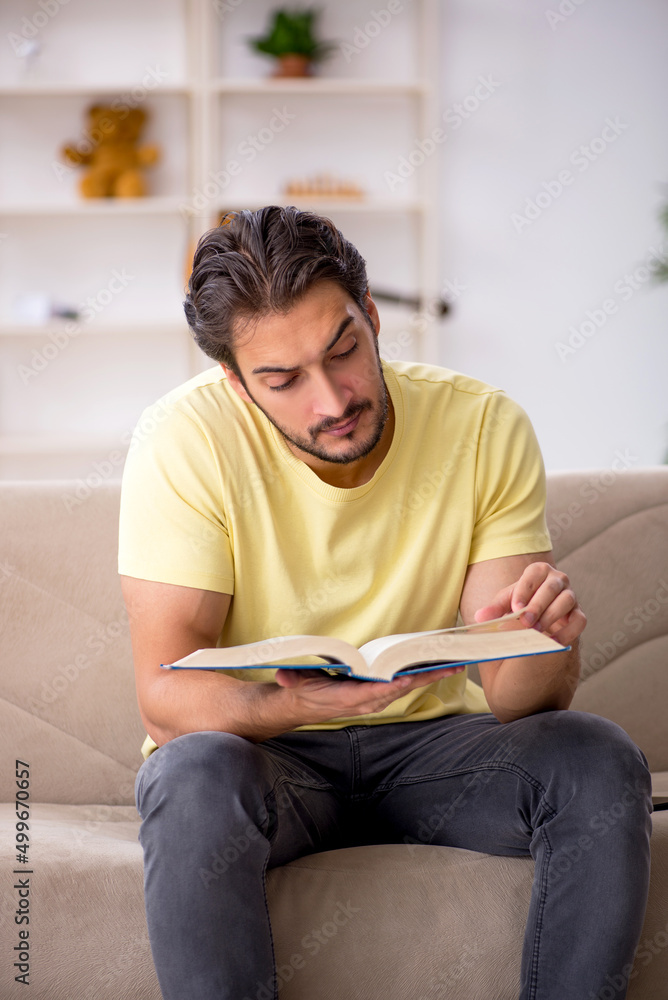 Young man reading book at home during pandemic Young man reading book at home during pandemic