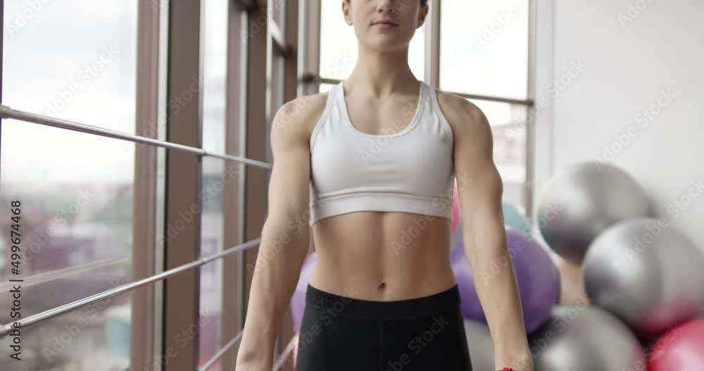 Young fit woman exercise with dumbbells in a fitness club Young fit woman exercise with dumbbells in a fitness club