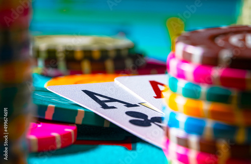 A set of colored poker chips and playing cards on game table. Risk concept - playing poker in casino. Poker game theme. Casino betting.